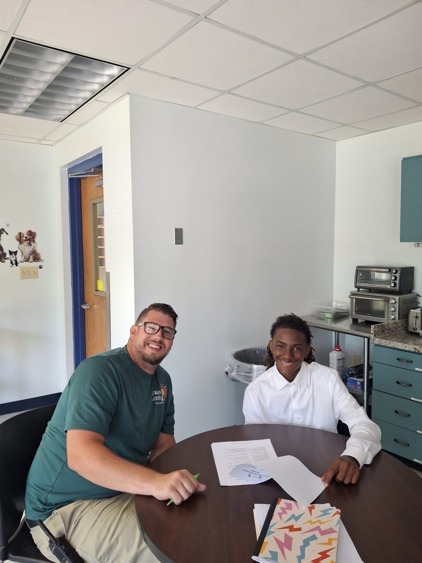 An NDCS job coach and a student going over worksite paperwork together