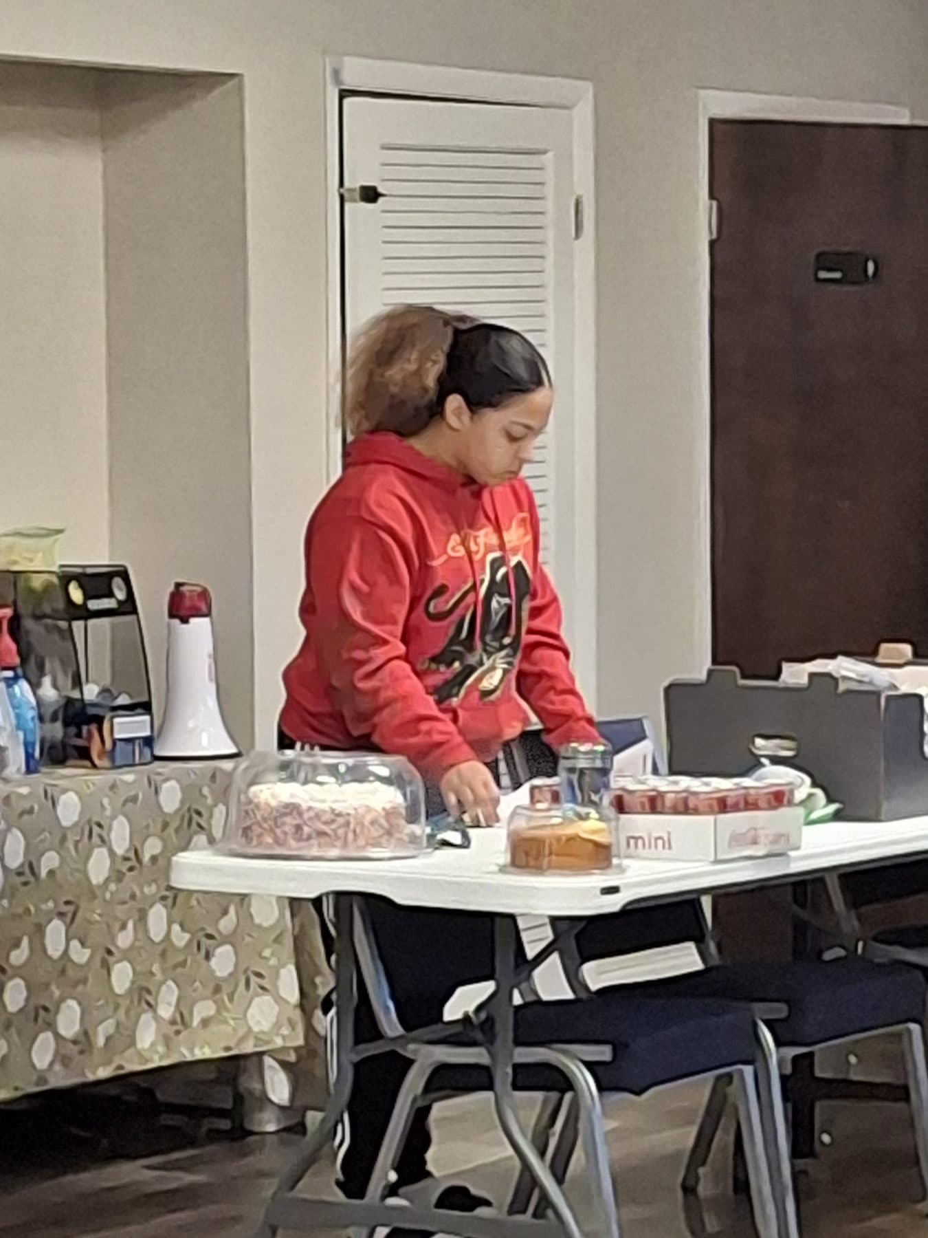 A participant setting up the refreshments table at a community event
