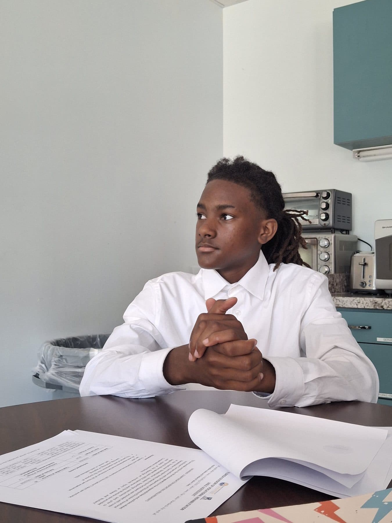 A student in professional dress seated with a document during interview practice